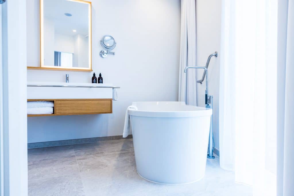 Lyst badeværelse med badekar på en Alsik Suite