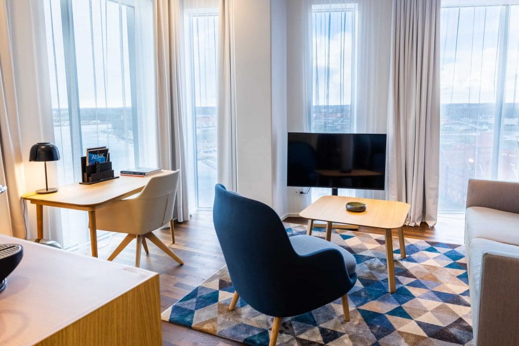 Lyst hotelværelse med udsigt, tv og lænestol